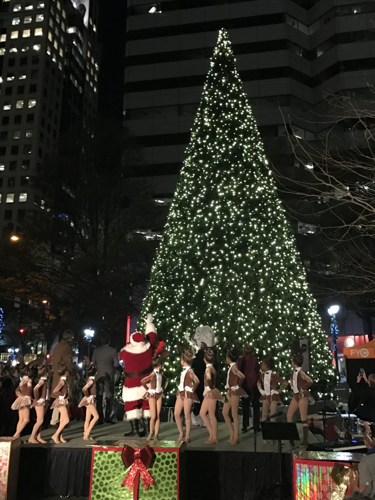 Santa and his reindeers lighting the Christmas tree